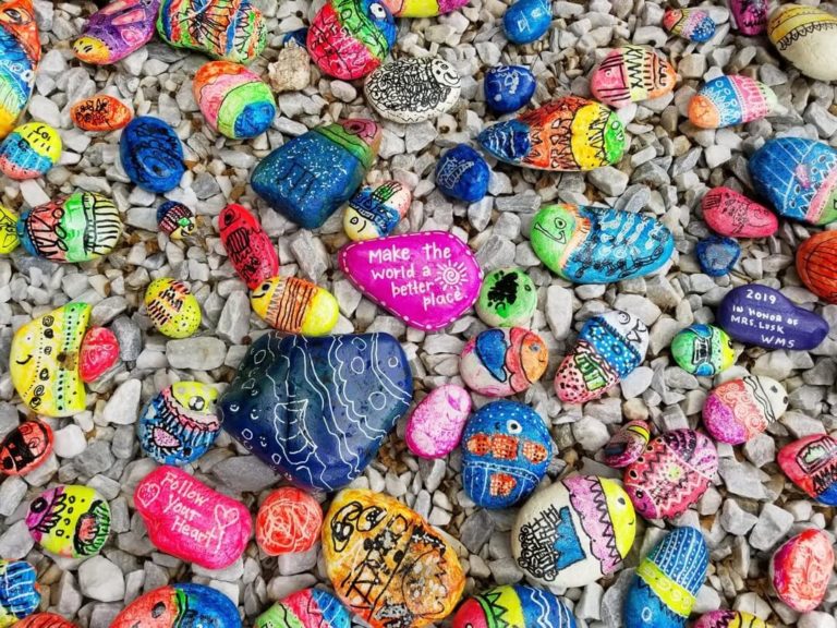 Pebbles painted with colourful messages of kindness